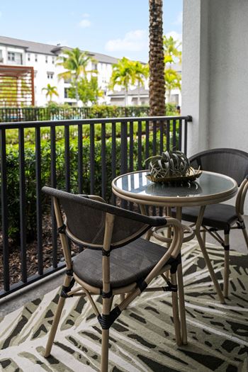 A patio with a table and chairs on a patio/balcony on a balcony